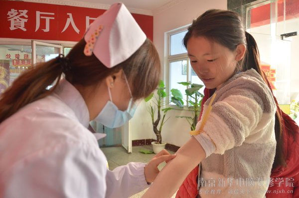 无偿献血车工作人员正在为同学们做献血前的检查